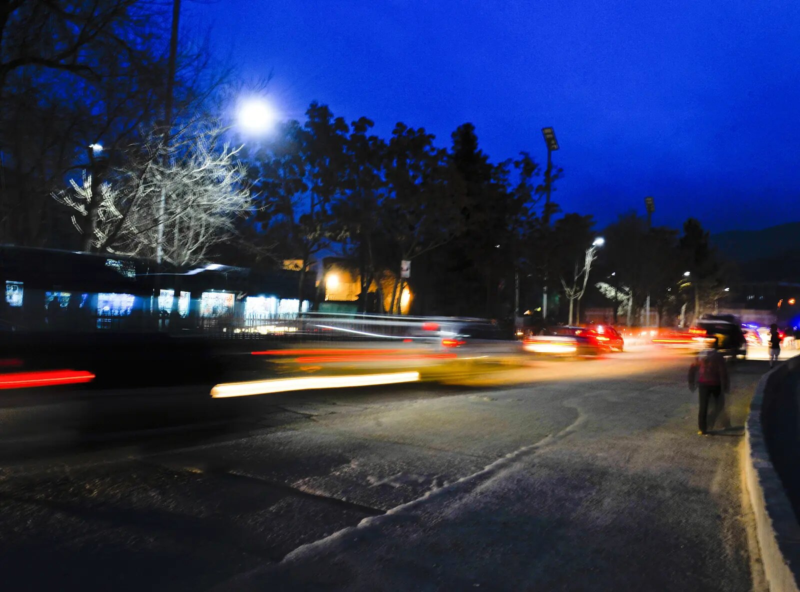 Solar-powered street lighting on a busy urban road at night