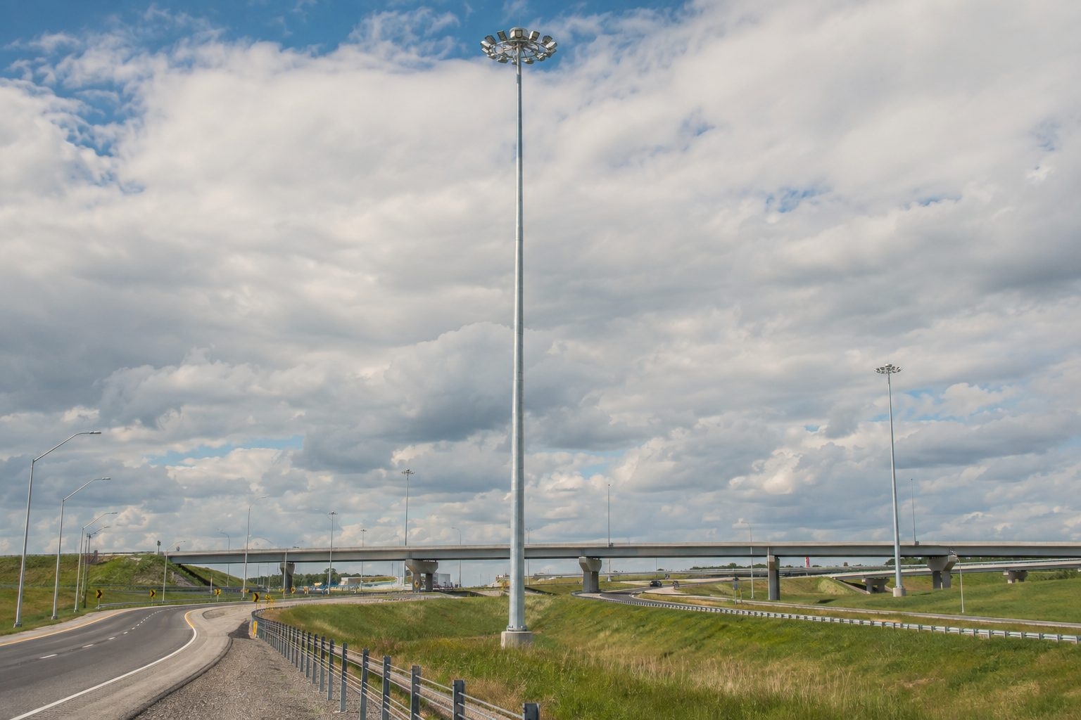 High-mast lighting towers exposed to wind at a highway interchange